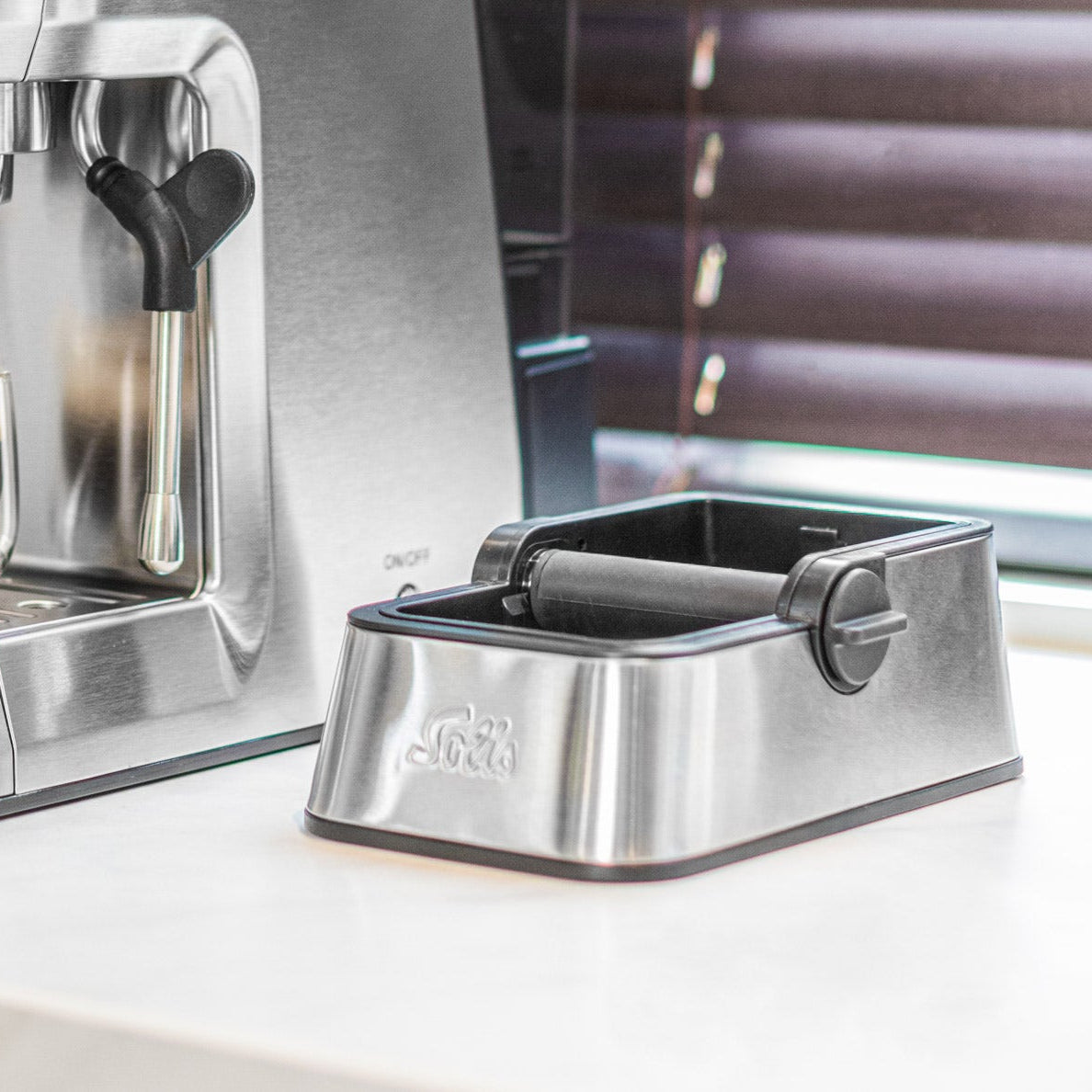 Solis Perfetta Ausklopfschale neben Espressomaschine in moderner Küche
