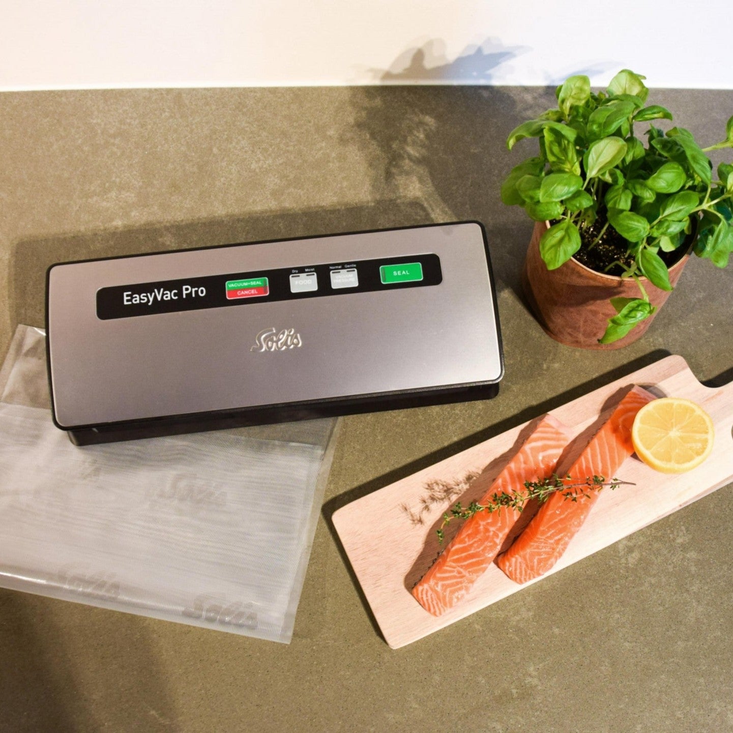 Solis EasyVac Pro Silber Vakuumierer auf Arbeitsplatte mit Lachs und Kräutern