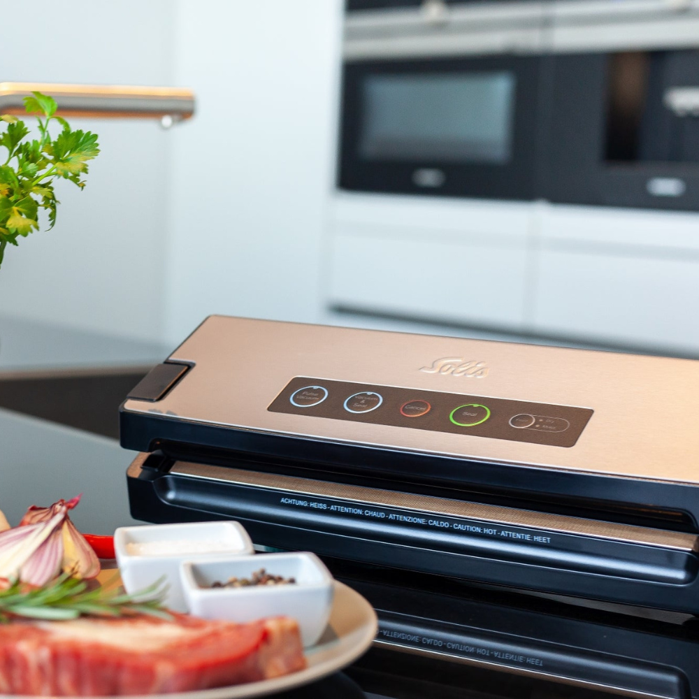 Solis Vac Premium Edelstahl Vakuumierer auf Küchentisch neben Fleisch und Gewürzen