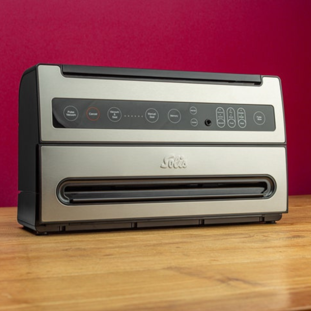 Solis VertiVac Vakuumierer auf Holztisch mit rotem Hintergrund